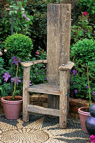 A_PLACE_TO_SIT_WOODEN_CHAIR_STANDING_ON_PEBBLE_SUNFLOWER_MOSAIC__CAPEL_MANOR_GARDEN_CHELSEA_FLOWER_S