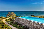 ANTIPAROS, GREECE, DESIGNER THOMAS DOXIADIS: SWIMMING POOL AND OLIVE TREE BESIDE THE SEA