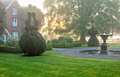 MITTON MANOR, STAFFORDSHIRE: THE MANOR AND FOUNTAIN IN FRONT. FOG, MIST, FOUNTAIN, TOPIARY, CLIPPED, WATER, SPRING, DAWN, SUNRISE, ENGLISH, COUNTRY, GARDEN