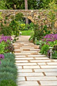 THE MOONGATE GARDEN, SUSSEX: PATH, PURBECK STONE WALL AND MOONGATE, ALLIUM FIRMAMENT, BOUNDARY, BOUNDARIES, BULBS, SPRING