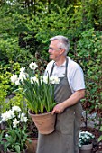 CLAUS DALBY GARDEN, DENMARK: CLAUS DALBY HOLDING TERRACOTTA CONTAINER OF WHITE NARCISSI