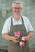 CLAUS DALBY GARDEN, DENMARK: CLAUS DALBY HOLDING FLOWERS OF TULIP- TULIP SILVER PARROT. TULIPS, SPRING, BULBS