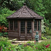 OCTAGONAL WOODEN SUMMERHOUSE WITH BOY STATUE IN FOREGROUND LITTLE COOPERS  HAMPSHIRE