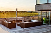 SEASIDE GARDEN DESIGNED BY ANTHONY PAUL: MODERN HOUSE, DECKING, LOUNGE, SEATS, FIREPLACE, CHIMNEY, COUNTRYSIDE BEYOND, BORROWED LANDSCAPE