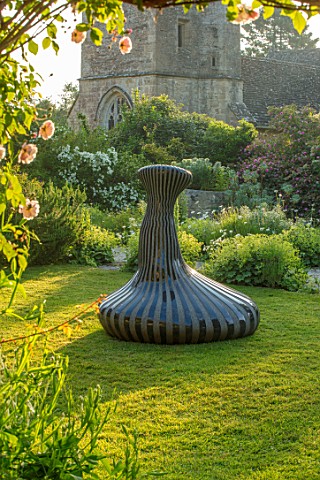 ASTHALL_MANOR_OXFORDSHIRE_CHURCH_SCULPTURE_THE_SINGER_OF_TALES_BY_JOHN_ISHERWOOD_LAWN_ALCHEMILLA_MOL