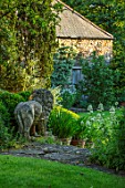 HARVARD FARM, DORSET: LION STATUE, STEPS, CENTRANTHUS AND AGAPANTHUS IN TERRACOTTA CONTAINERS ON GRANARY STEPS