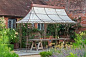 THE WALLED GARDEN AT COWDRAY, WEST SUSSEX: OUTDOOR DINING, SEATING AREA WITH RUSTY METAL PERGOLA, AWNING, PLACE TO SIT, DINING, AL FRESCO, ENTERTAINING