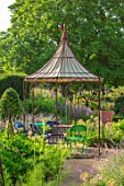 THE WALLED GARDEN AT COWDRAY, WEST SUSSEX: OUTDOOR DINING, SEATING AREA TABLE, CHAIRS, BOX PARTERRES, GREEN, ENGLISH, COUNTRY, GARDEN, AWNING, GAZEBO, AL FRESCO