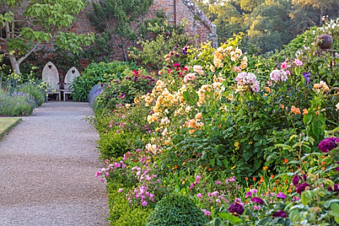 THE_WALLED_GARDEN_AT_COWDRAY_WEST_SUSSEX_ENGLISH_COUNTRY_GARDEN_BORDERS_OF_YELLOW_RED_FLOWERED_ROSES