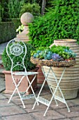 MITTON MANOR, STAFFORDSHIRE: TABLE AND CHAIRS ON TERRACE WITH TERRACOTTA CONTAINER AND CONTAINER PLANTED WITH SUCCULENTS