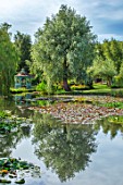BENNETTS WATER GARDENS, DORSET: LAKE, WATER LILIES, WATERLILIES, BLUE, PAINTED, SUMMER HOUSE, GAZEBO, ENGLISH, POND, POOL, PINK, FLOWERING, WILLOWS, REFLECTIONS, REFLECTED