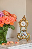 PYTTS HOUSE, OXFORDSHIRE: CLOCK AND PINK ROSES IN VASE IN MASTER BEDROOM
