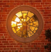 MORTON HALL, WORCESTERSHIRE: WEST GARDEN: SUNSET, ROUND WINDOW ON HALL WALL