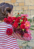 ALHAM FARM, SOMERSET: CORNISHWARE: KARINA RICKARDS HOLDING FLOWERS AT HER FRONT DOOR