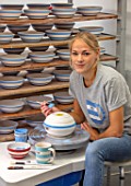 ALHAM FARM, SOMERSET: CORNISHWARE: THE POTTERY - VICKY APPLYING ICONIC BLUE STRIPE BY HAND TO FIRED BOWLS