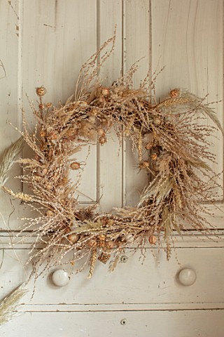 FLOWERS_FROM_THE_FARM_MARBURY_HALL_DESIGNER_SOFIE_PATONSMITH_DRIED_SEED_HEAD_WREATH_ON_CUPBOARD_DOOR
