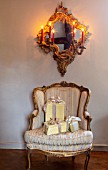 PYTTS HOUSE, OXFORDSHIRE: LIVING ROOM, CHRISTMAS: PRESENTS ON CHAIR WITH MIRROR ABOVE