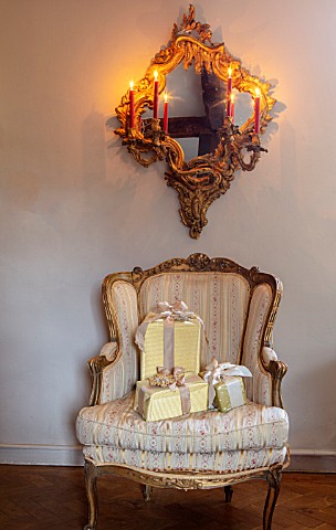 PYTTS_HOUSE_OXFORDSHIRE_LIVING_ROOM_CHRISTMAS_PRESENTS_ON_CHAIR_WITH_MIRROR_ABOVE