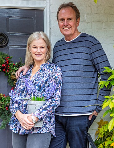 GIBBONS_CROFT_WEST_CLANDON_SURREY_CHRISTMAS__OWNERS_BRUCE_AND_LOUISE_STEWART_BY_THE_FRONT_DOOR
