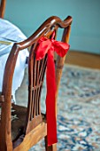 MARBURY HALL, SHROPSHIRE: DESIGNER SOFIE PATON-SMITH - SWEDISH CHRISTMAS, PALE BLUE DINING ROOM, RED RIBBON DECORATION ON BACK OF CHAIR
