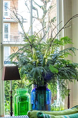 BUTTER_WAKEFIELD_HOUSE_LONDON_CHRISTMAS__LIVING_ROOM_BLUE_VASE_WITH_FOLIAGE_AND_AMARYLLIS_BY_FRONT_W