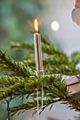 MERRYWOOD, JACKY HOBBS HOUSE, LONDON: CHRISTMAS TREE DETAIL WITH SILVER CANDLE AND FLAME