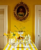 MARBURY HALL, SHROPSHIRE: DESIGNER SOFIE PATON-SMITH - YELLOW HALLWAY, TABLE, YELLOW AND WHITE TABLECLOTH, DAFFODILS IN WHITE VASES, CONTAINERS
