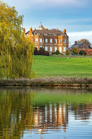 THENFORD_GARDENS__ARBORETUM_NORTHAMPTONSHIRE_REFLECTION_OF_HOUSE_IN_LAKE_POND_WILLOW_SPRING_WATER