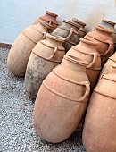 TAROUDANT, MOROCCO: DESIGNERS ARNAUD MAURIERES AND ERIC OSSART: DAR AL HOSSOUN - TERRACOTTA CONTAINERS BESIDE WALL