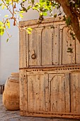 TAROUDANT, MOROCCO: DESIGNERS ARNAUD MAURIERES AND ERIC OSSART: DAR AL HOSSOUN, COURTYARD, WOODEN CABINET, TERRACOTTA CONTAINER