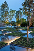 RADICEPURA GARDEN FESTIVAL, SICILY, ITALY: HOME GROUND BY ANTONIO PERAZZI. WATER GARDEN WITH TREES, WATER FEATURE, PALM TREES, LIGHTING, NIGHT, LIGHTS