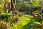 THE COACH HOUSE, SURREY, DESIGNER BARBARA BROOKS: LAWN, PATH, BORDERS WITH TULIPS, WHITE BENCH, SEAT, WALL, SPRING, GARDEN, TULIPA BALLERINA, HOLLYWOOD, NIGHTRIDER