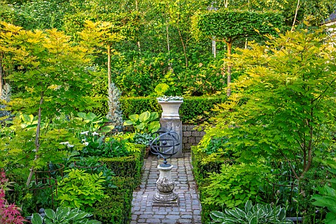 CLAUS_DALBY_GARDEN_DENMARK_VIEW_ALONG_PATH_TO_TERRACE_FOLIAGE_LEAVES_GREEN_HOSTAS_IN_CONTAINERS_ACER