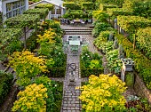 CLAUS DALBY GARDEN, DENMARK: VIEW ALONG PATH TO SEATING AREA, PATIO, TABLE, CHAIRS, TERRACE, FOLIAGE, LEAVES, GREEN, HOSTAS IN CONTAINERS, ACER SHIRASAWANUM, SHRUB, FULLMOON MAPLE