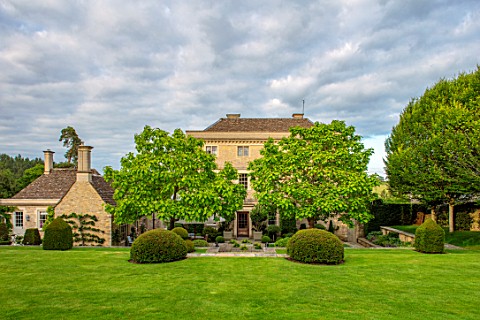 WINSON_MANOR_GLOUCESTERSHIRE_LAWN_MANOR_HOUSE_YEW_TOPIARY_CLIPPED_CATALPAS_SUMMER_ENGLISH_COUNTRY_GA