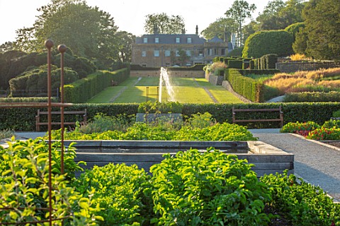THE_NEWT_IN_SOMERSET_VIEW_TO_HOUSE_ACROSS_KITCHEN_GARDEN_POTAGER_BATHING_POND_FOUNTAIN_LONG_GRASS_WA