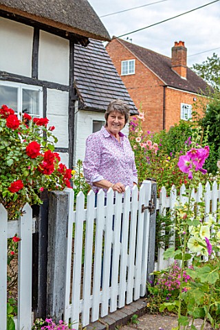 THATCH_COTTAGE_WORCESTERSHIRE_OWNER_MARY_COX_AT_THE_WHITE_FRONT_GATE_OF_HER_COTTAGE