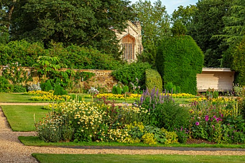 CANONS_ASHBY_NORTHAMPTONSHIRE_THE_NATIONAL_TRUST__LAWN_BEDDING_CHURCH_BORDER_WITH_ANTHEMIS_SUSANNA_M