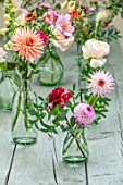 GREEN AND GORGEOUS FLOWERS, OXFORDSHIRE: TABLE ARRANGEMENT OF GLASS VASES FOR WEDDING ALONG GREY, BLUE TABLE - DAHLIAS, FALL, AUTUMN, BLOOMING, BULBS