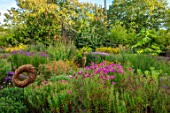 THE PICTON GARDEN AND OLD COURT NURSERIES, WORCESTERSHIRE: BORDERS OF ASTERS, BRONZE PAMONA SCULPTURE BY VICTORIA WESTAWAY, SEPTEMBER, FALL