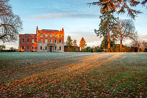 MORTON_HALL_GARDENS_WORCESTERSHIRE_THE_HALL_LAWN_FROST_WINTER_SUNRISE_GRASS_FALLEN_LEAVES