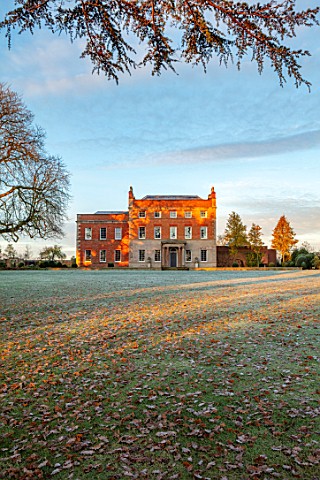 MORTON_HALL_GARDENS_WORCESTERSHIRE_THE_HALL_LAWN_FROST_WINTER_SUNRISE_GRASS_FALLEN_LEAVES