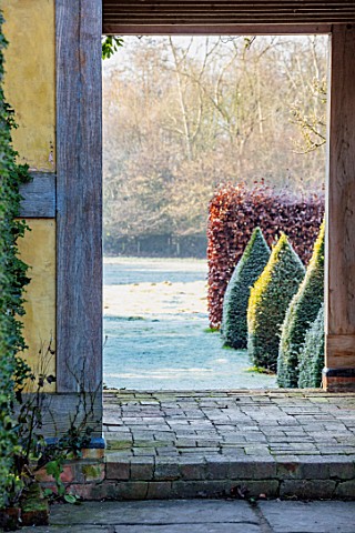 BRYANS_GROUND_HEREFORDSHIRE_THE_DOVECOTE_GARDEN_BUILDING_DOORWAY_CLIPPED_YEW_TOPIARY_OBELISKS_VIEW_O