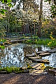 MORTON HALL GARDENS, WORCESTERSHIRE: POOL, WATER, STEPPING STONES, REFLECTIONS, CHERRIES, PRUNUS INCISA YAMADEI, UPPER POND, STROLL GARDEN, JAPANESE, MARCH, SPRING