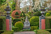 THE LASKETT GARDENS, HEREFORDSHIRE. DESIGNER ROY STRONG - THE SERPENTINE WALK - STATUE OF BRITANNIA, PATHS, CLIPPED, TOPIARY, BOX, HOLLY, ILEX, BUXUS, SPRING, APRIL