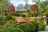 THE LASKETT GARDENS, HEREFORDSHIRE. DESIGNER ROY STRONG - THE HOWDAH COURT, WALL, CLIPPED TOPIARY, FORMAL GARDEN, APRIL, SPRING