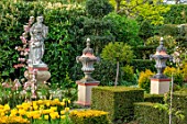 THE LASKETT GARDENS, HEREFORDSHIRE. DESIGNER ROY STRONG - THE HOWDAH COURT, STATUE, MALUS FLORIBUNDA, CLIPPED TOPIARY YEW, STATUE, FORMAL GARDEN, APRIL, SPRING