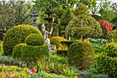 THE LASKETT GARDENS, HEREFORDSHIRE. DESIGNER ROY STRONG - THE SERPENTINE WALK, CLIPPED TOPIARY YEW, BOX, HOLLY, BEECH, PRIVET, GREEN, SPRING, APRIL, STATUE OF BRITANNIA