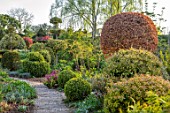 THE LASKETT GARDENS, HEREFORDSHIRE. DESIGNER ROY STRONG - THE SERPENTINE WALK, CLIPPED TOPIARY YEW, BOX, HOLLY, BEECH, PRIVET, GREEN, SPRING, APRIL