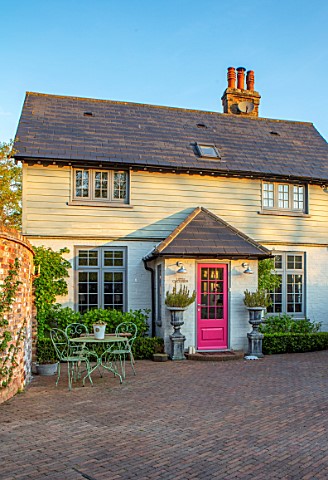 LITTLE_ORCHARDS_SURREY_DESIGNER_NIC_HOWARD_THE_FRONT_OF_THE_HOUSE_DRIVE_PINK_DOOR_METAL_TABLE_AND_CH